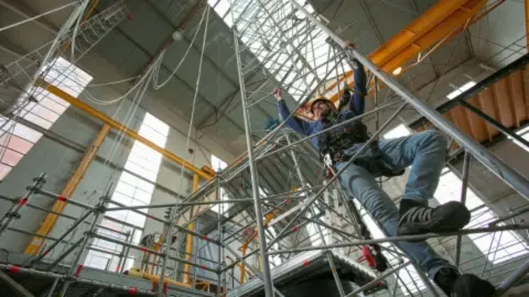 man klimt in stellage