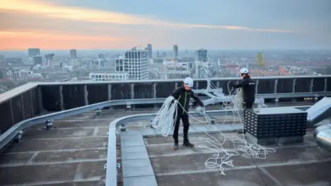 personen met kabels op dak| DID-online.nl