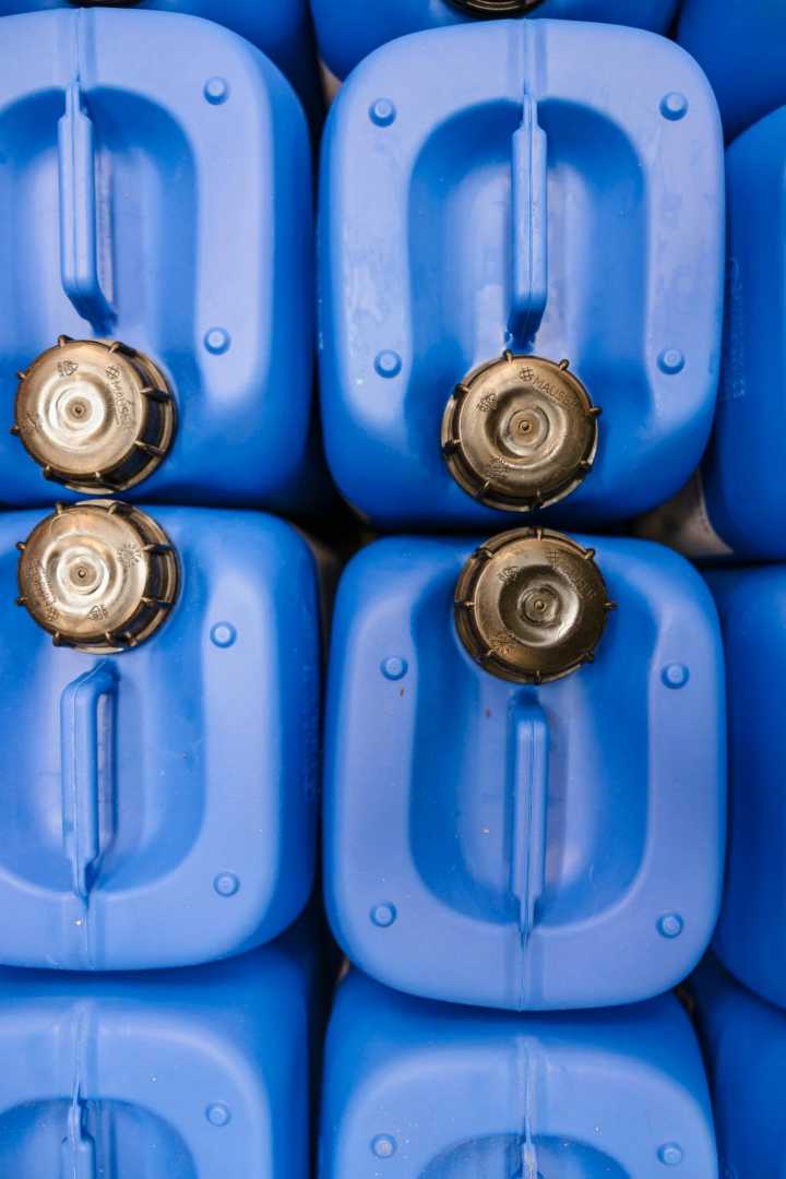 Productie van chemische middelen in opdracht Blauwe jerrycans met zwarte doppen