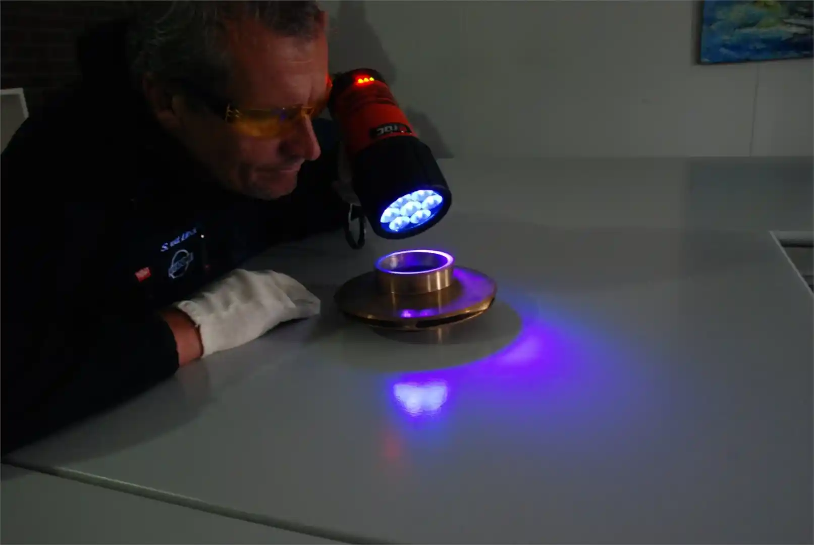 Ultra Clean reinigen (Zuurstofschoon) man bekijkt metaal voorwerp met uv licht