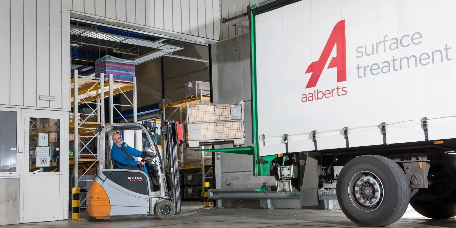 man met heftruck laadt vrachtwagen in