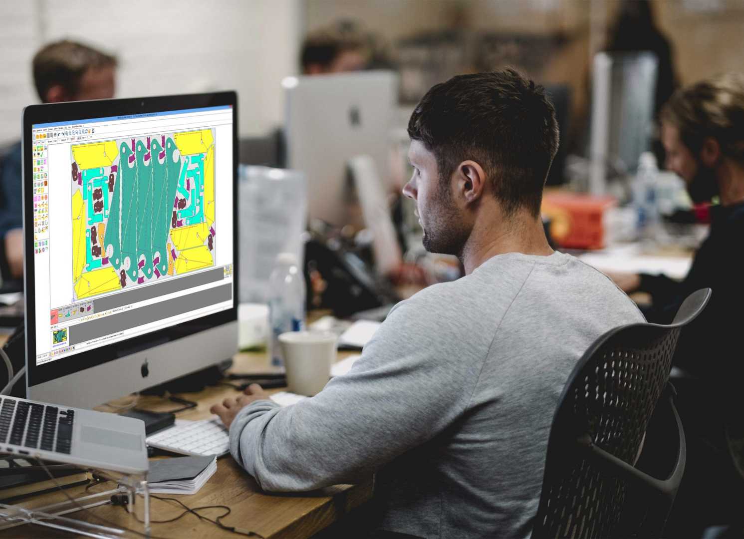 man werkt achter computer met tekenprogramma